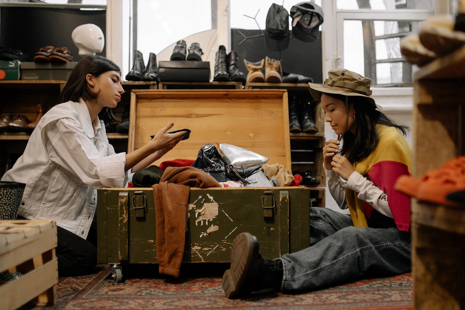 Two women sitting on the floor and browsing clothes